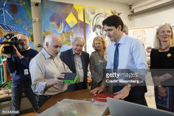 Justin Trudeau, Canada's prime minister, right, listens while Dan Craigen, founding president of Global EPIC, displays an affordable cybersecurity...