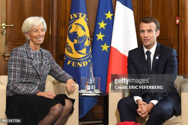 International Monetary Fund director Christine Lagarde speaks with French President Emmanuel Macron during the first day of a two-day conference on...