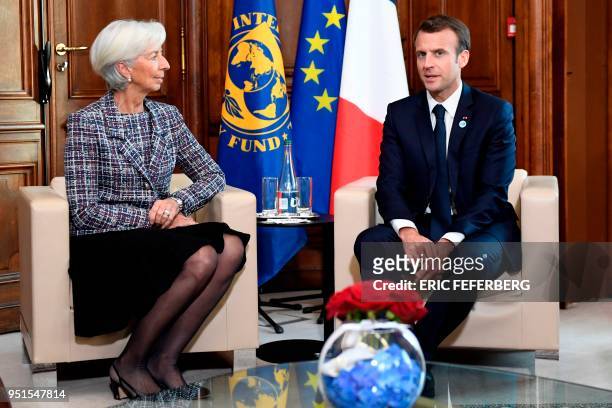 International Monetary Fund director Christine Lagarde speaks with French President Emmanuel Macron during the first day of a two-day conference on...