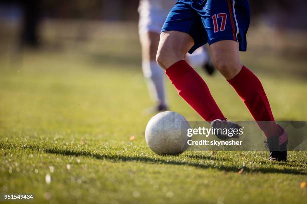 nicht erkennbare fußballspieler dribbeln den ball auf ein spiel. - frauenfußball stock-fotos und bilder