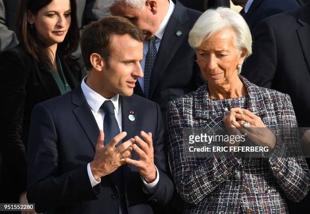 French President Emmanuel Macron speaks with International Monetary Fund director Christine Lagarde after posing for a photograph on April 26, 2018...
