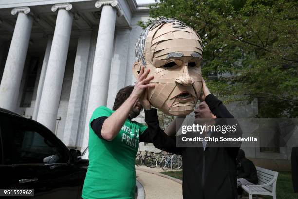 Lukas Ross of Friends of the Earth puts on a giant mask of Environmental Protection Agency Administrator Scott Pruitt while protesting outside the...