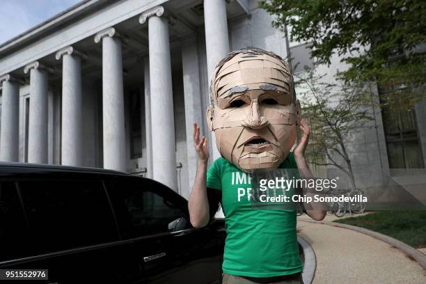Lukas Ross of Friends of the Earth wears a giant mask of Environmental Protection Agency Administrator Scott Pruitt while protesting outside the...