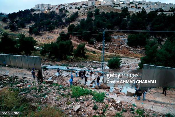 Picture taken on April 26, 2018 shows Palestinians from the Shuafat refugee camp in east Jerusalem standing on part of the controversial Israeli...