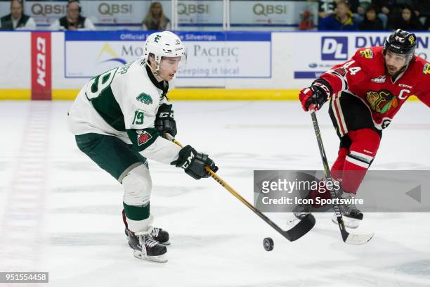 Everett Silvertips forward Bryce Kindopp dumps the puck into the offensive zone out of the reach of Portland Winterhawks defenseman Keoni Texeira in...