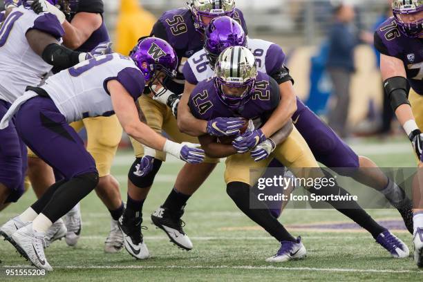 DSEATTLE, WA Tailback Kamari Pleasant is tackled by linebacker Nick Harris during the University of Washington Spring Game at Husky Stadium on...