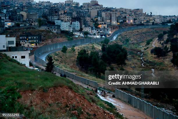 Picture taken on April 26, 2018 shows Palestinians from the Shuafat refugee camp in east Jerusalem standing on part of the controversial Israeli...