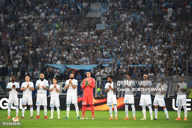 Marseille's players applaud during a tribute to late former France football coach Henri Michel who did a few days prior before to the UEFA Europa...