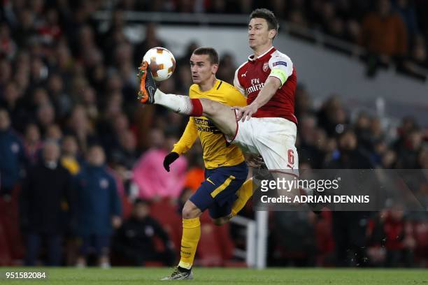 Atletico Madrid's French striker Antoine Griezmann vies with Arsenal's French defender Laurent Koscielny on his way to scoring their first goal...