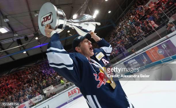 Jason Jaffray of EHC Red Bull Muenchen holds up the German Championship trophy after winning the DEL Play-offs Final Match 7 between EHC Red Bull...