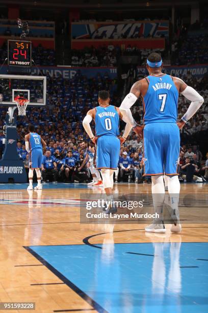 Carmelo Anthony of the Oklahoma City Thunder and Russell Westbrook of the Oklahoma City Thunder look on as Paul George of the Oklahoma City Thunder...