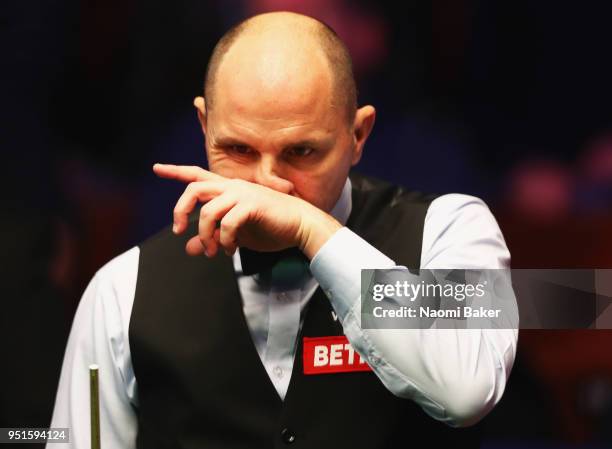 Joe Perry of England reacts during his second round match against Mark Allen of Northern Ireland during day six of the World Snooker Championship at...