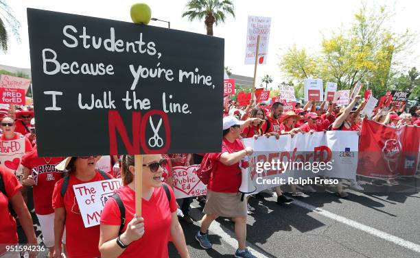 Arizona teachers march through downtown Phoenix on their way to the State Capitol as part of a rally for the #REDforED movement on April 26, 2018 in...