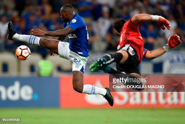 Sassa of Brazil's Cruzeiro and goalkeeper Johnny Herrera of Chile's Universidad de Chile jump in the air for the ball during their Copa Libertadores...