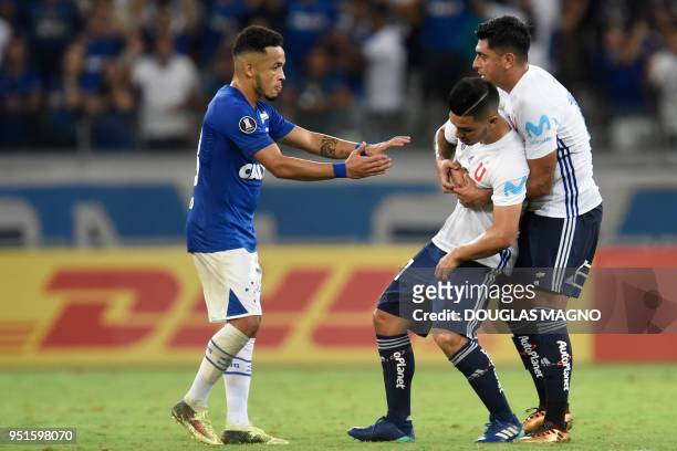 Rafinha of Brazil's Cruzeiro and Gonzalo Jara of Chile's Universidad de Chile confort Lorenzo Reyes at the end of their Copa Libertadores football...