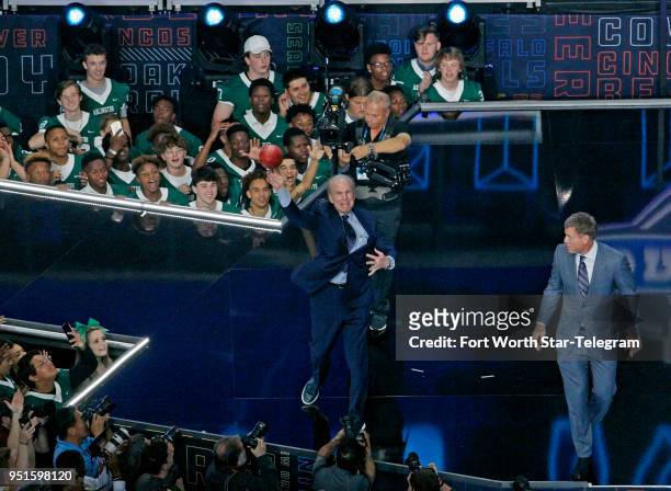 Former Dallas Cowboys players Roger Staubach and Troy Aikman on stage after throwing footballs to the crowd before the first pick of the first round...