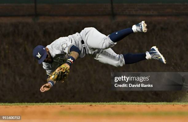 Jonathan Villar of the Milwaukee Brewers tries to make a play on an infield single hit by Addison Russell of the Chicago Cubs during the second...