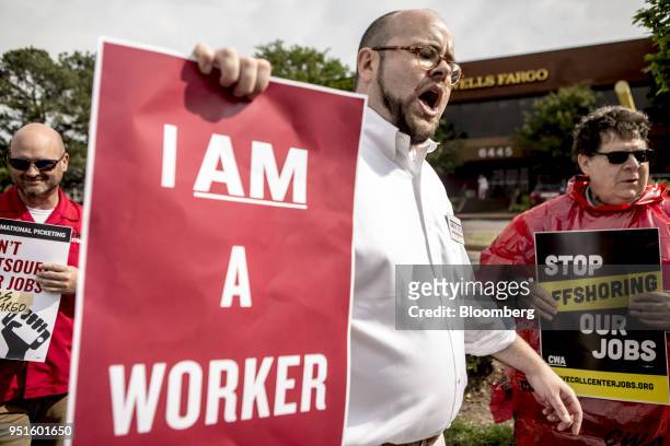 Demonstrators hold signs during a protest against Wells Fargo & Co.'s plans to offshore thousands of jobs in Memphis, Tennessee, U.S., on Thursday,...