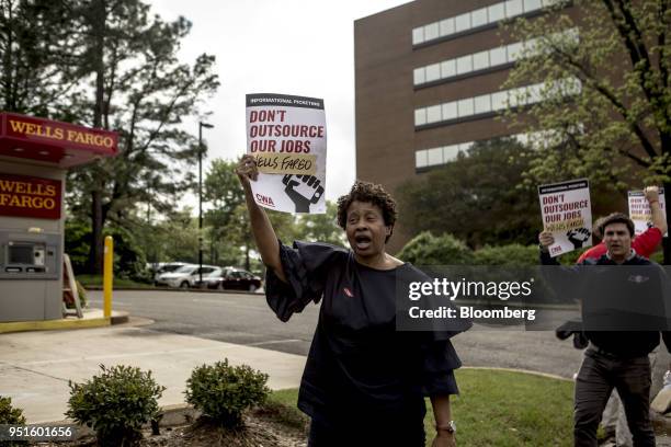 Demonstrators hold signs during a protest against Wells Fargo & Co.'s plans to offshore thousands of jobs in Memphis, Tennessee, U.S., on Thursday,...