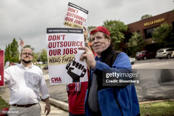 Demonstrators hold signs during a protest against Wells Fargo & Co.'s plans to offshore thousands of jobs in Memphis, Tennessee, U.S., on Thursday,...