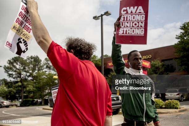 Demonstrators hold signs during a protest against Wells Fargo & Co.'s plans to offshore thousands of jobs in Memphis, Tennessee, U.S., on Thursday,...