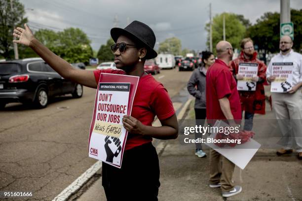 Demonstrators hold signs during a protest against Wells Fargo & Co.'s plans to offshore thousands of jobs in Memphis, Tennessee, U.S., on Thursday,...