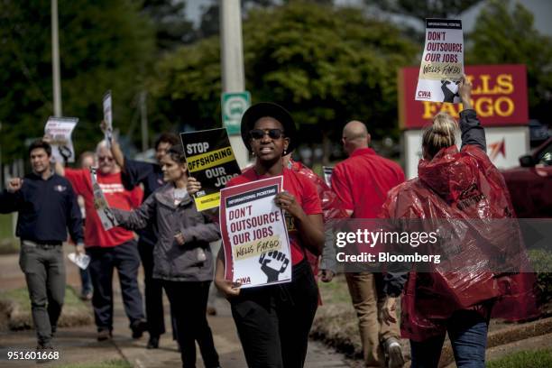 Demonstrators hold signs during a protest against Wells Fargo & Co.'s plans to offshore thousands of jobs in Memphis, Tennessee, U.S., on Thursday,...