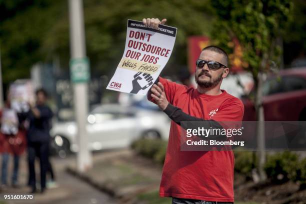 Demonstrator holds a sign during a protest against Wells Fargo & Co.'s plans to offshore thousands of jobs in Memphis, Tennessee, U.S., on Thursday,...