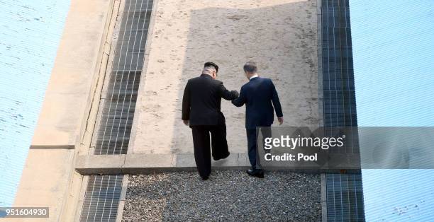 North Korean leader Kim Jong Un takes hand of South Korean President Moon Jae-in to cross the military demarcation line to the north side upon...