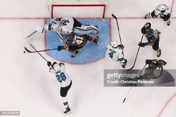 Pierre-Edouard Bellemare of the Vegas Golden Knights attempts to play the puck ahead of Timo Meier and goaltender Martin Jones of the San Jose Sharks...