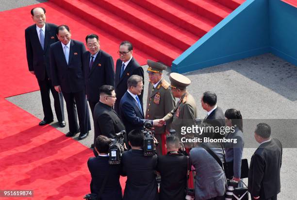 North Korean leader Kim Jong Un, center left, stands with South Korean President Moon Jae-in, center, as he shakes hands with a North Korean...