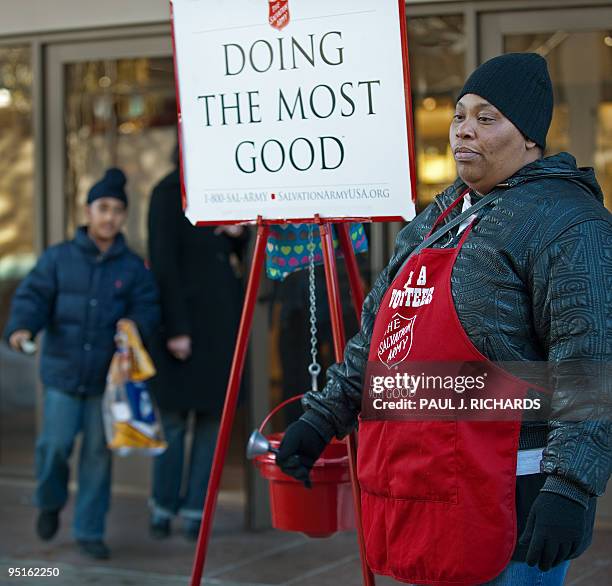 Young Sikh-American boy heads toward Salvation Army bell-ringer Margaret Carpin with a donation outside a major department store seeking donations at...