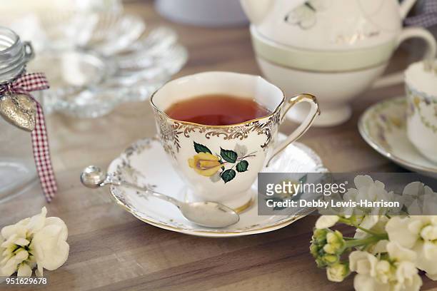 quaint teacup and saucer on table - english tea stock-fotos und bilder