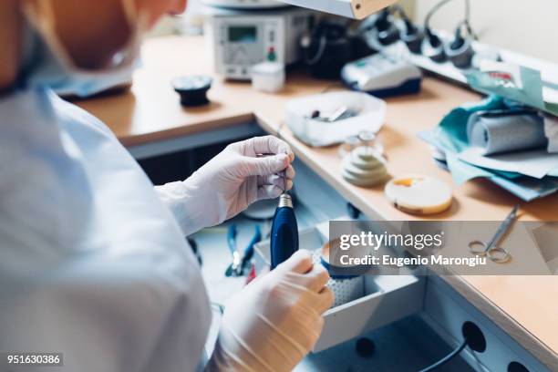 female dentist handling dentistry equipment in dentist office, mid section - dental assistant stock pictures, royalty-free photos & images