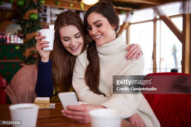 young women smiling over text message on mobile phone - gpointstudio imagens e fotografias de stock