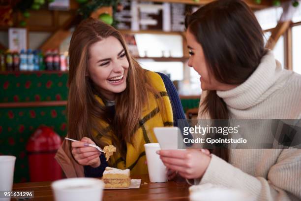 young women smiling over text message on mobile phone - tea for two stock-fotos und bilder
