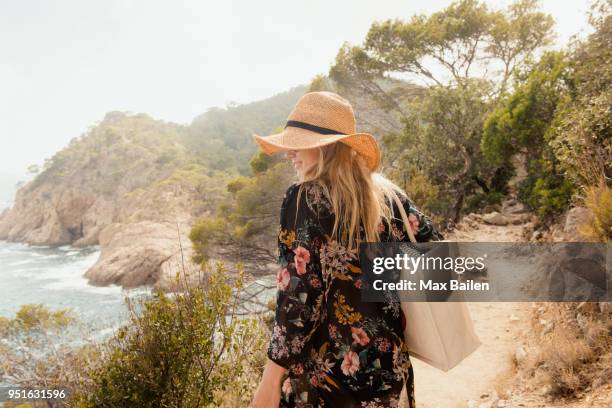 woman walking along coastal pathway, rear view, tossa de mar, catalonia, spain - tossa de mar bildbanksfoton och bilder