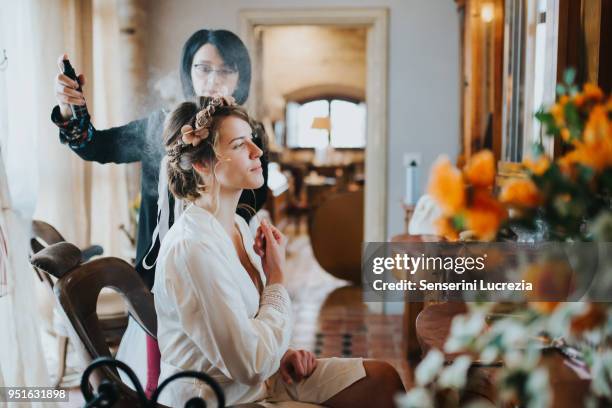 bride preparing for wedding with hairstylist - luxury hair stock-fotos und bilder