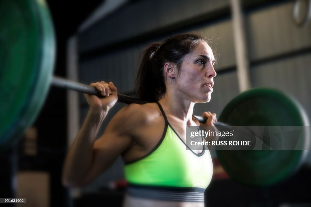 Woman exercising in gym, using barbell