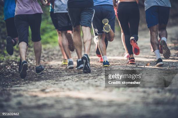 achteraanzicht van onherkenbaar atleten lopen van een marathon in de natuur. - male feet pics stockfoto's en -beelden