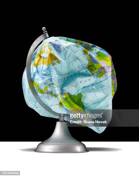 deflated globe - world politics stockfoto's en -beelden