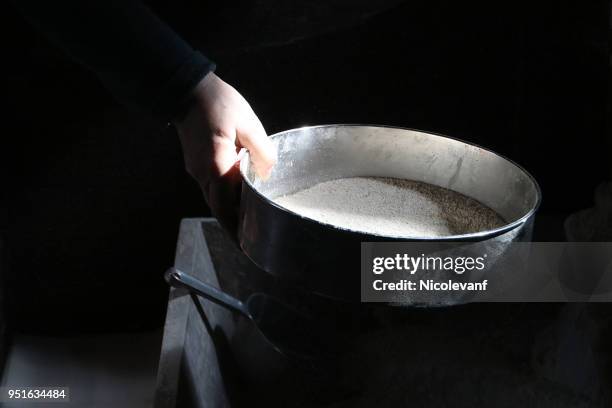 woman sieving flour in a mill - sieve stock pictures, royalty-free photos & images