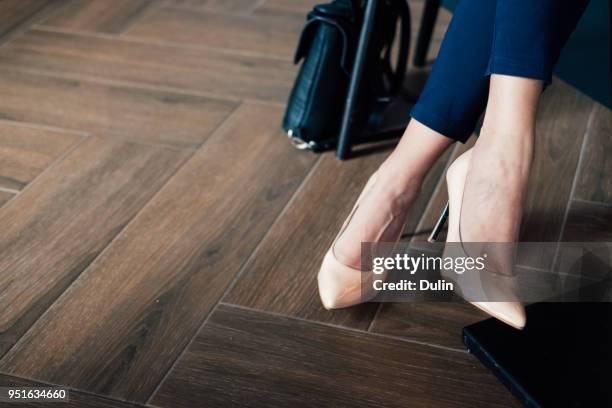 close-up of a businesswomans legs in a trouser suit and stiletto heals - schneidersitz stock-fotos und bilder