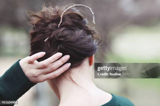 woman putting up her hair with a twig - twig stock pictures, royalty-free photos & images