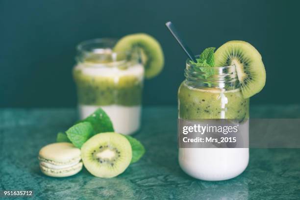 two pots of natural yogurt with kiwi and fresh mint - yoghurt pot stock-fotos und bilder