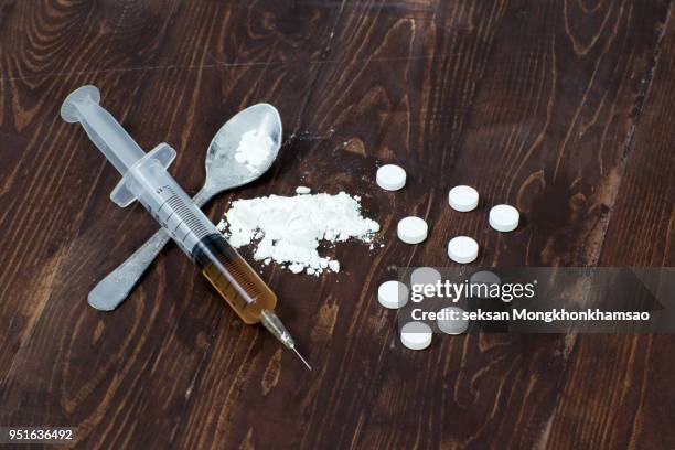 drug syringe and cooked heroin - heroïne stockfoto's en -beelden