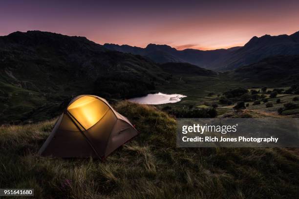 tent at dusk in english lake district - camping photos et images de collection