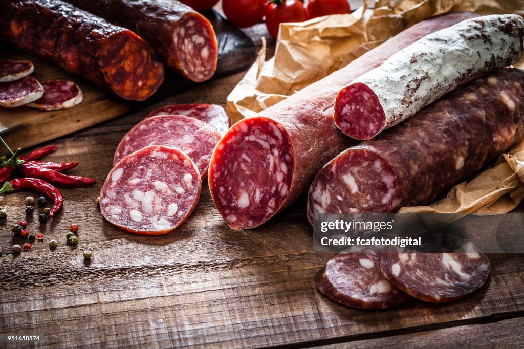 素朴な木製のテーブル上の混合スペインのチョリソ部分