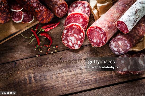 gemischte spanische chorizo stücke grenze auf rustikalen holztisch - sausage stock-fotos und bilder