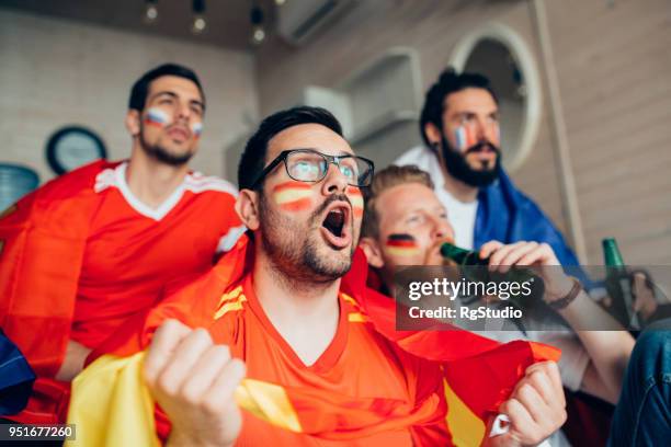 männlichen fußball-anhänger schreien beim spiel mit freunden zu schauen - germany football stock-fotos und bilder